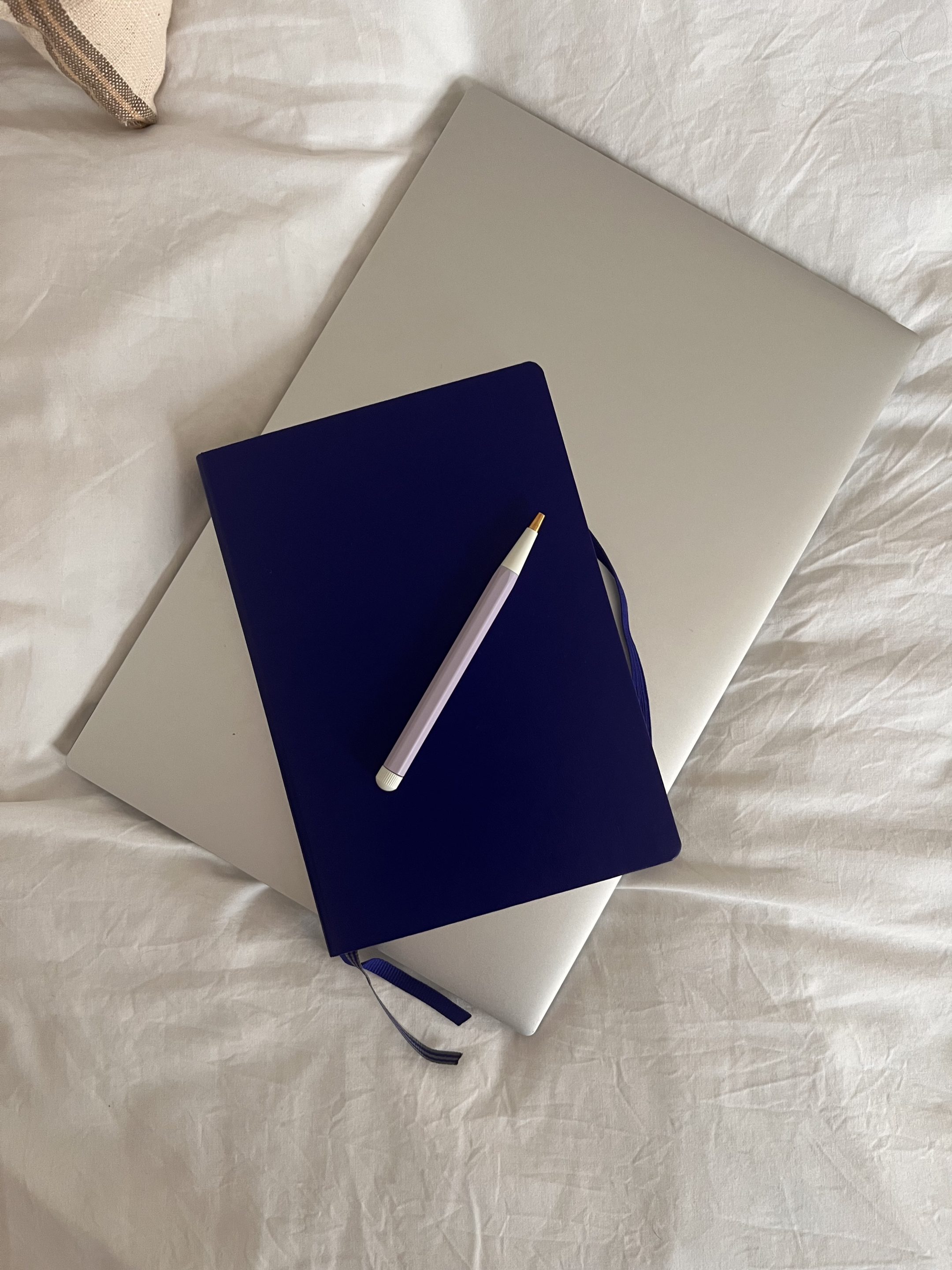 Modern workspace setup for freelance copywriting with laptop and journal.
